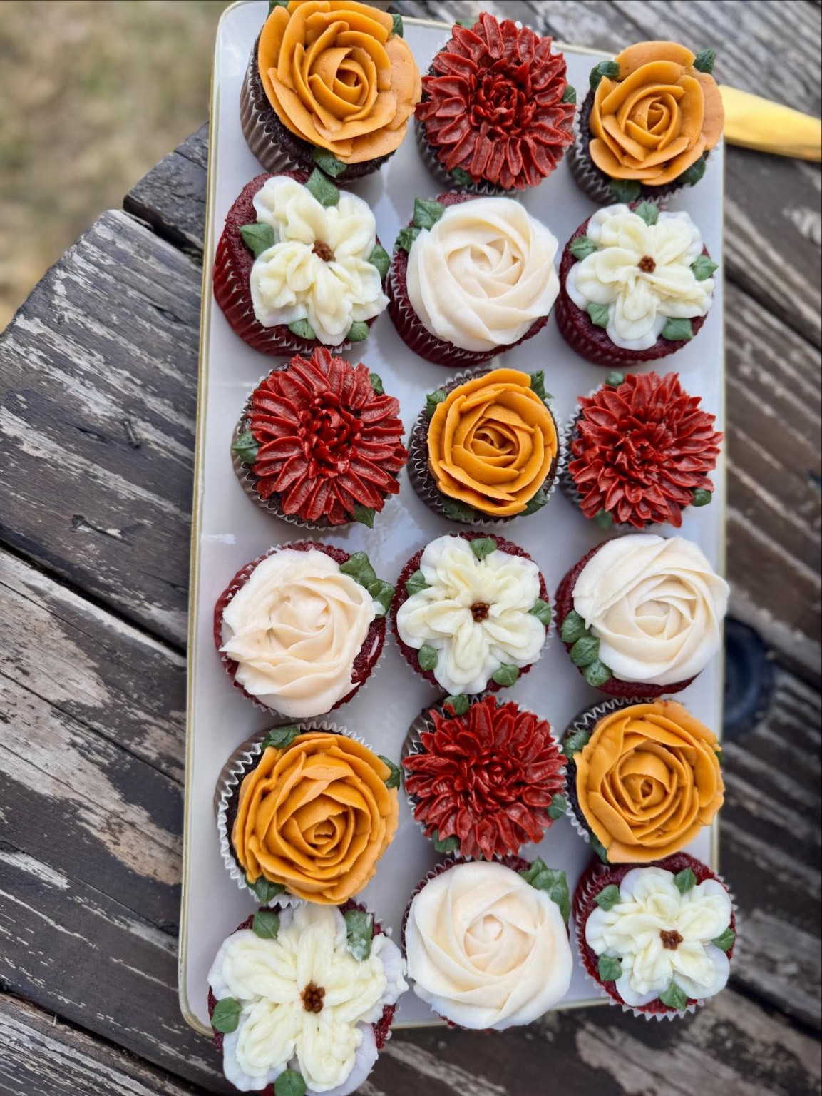 18 beautifully decorated fall floral cupcakes with buttercream roses, dahlias, and ranunculus