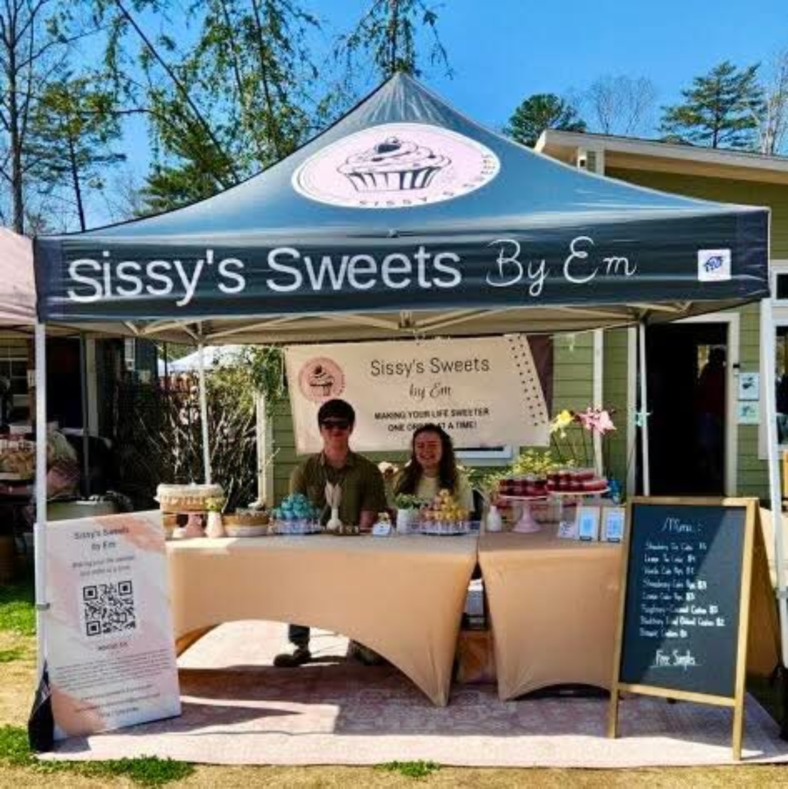 Emily Vargas at her Sissy's Sweets by Em market booth with a full dessert display