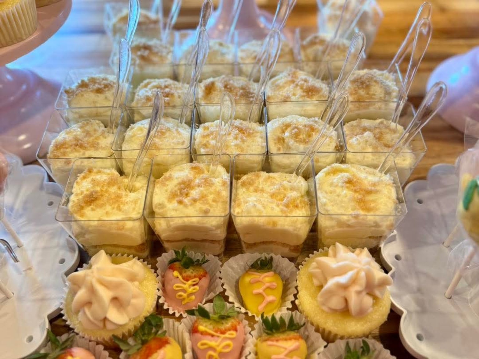 Event dessert spread with banana pudding cups, mini cupcakes, and chocolate-dipped strawberries